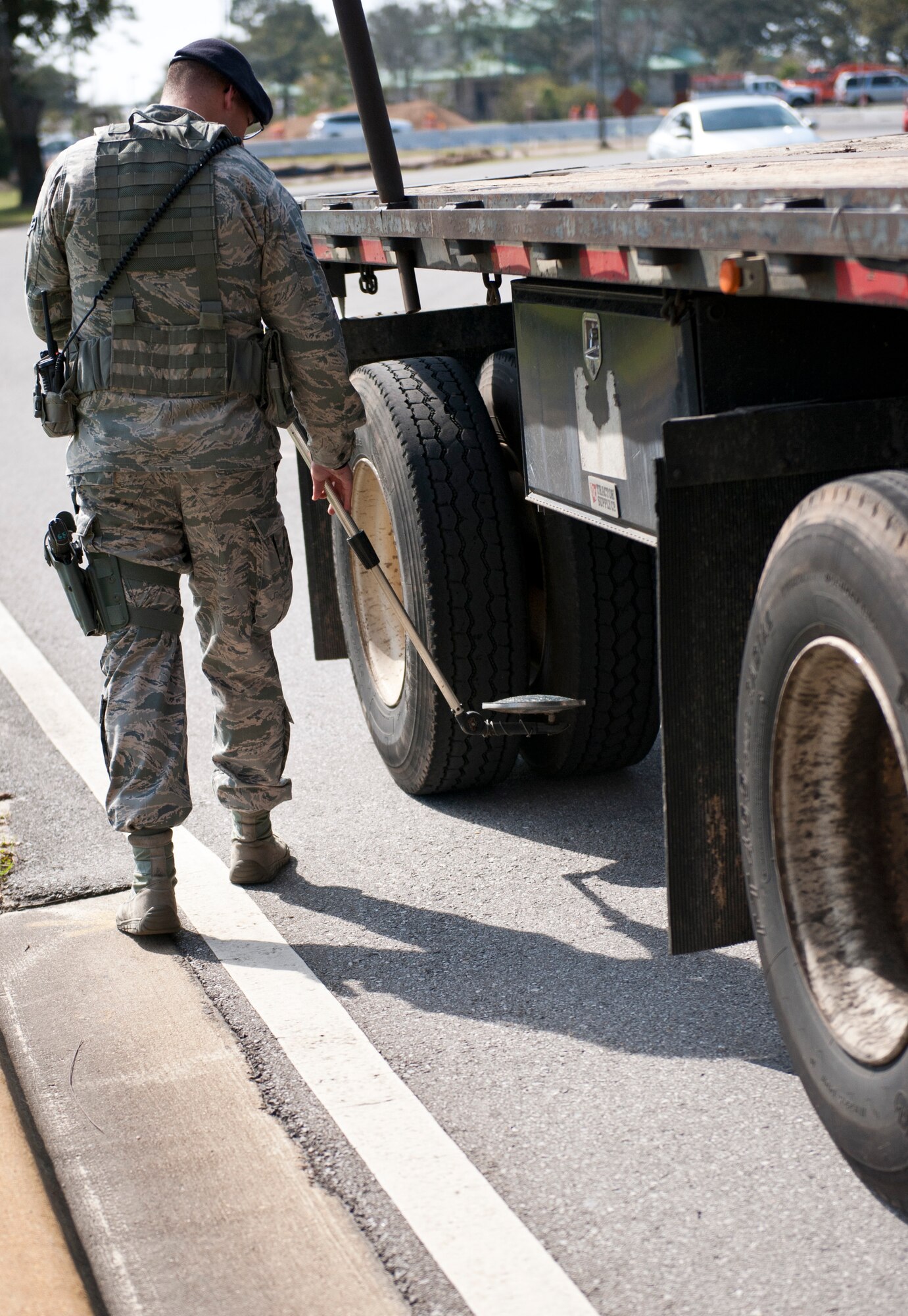 Airman 1st Class Richard Thomas, 1st Special Operations Security Forces Squadron alarm monitor, uses a mirror to look under a vehicle at the commercial gate on Hurlburt Field, Fla., Feb. 24, 2014. (U.S. Air Force photo/Senior Airman Krystal M. Garrett) 