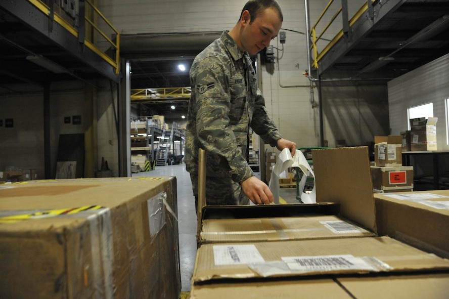 Airman 1st Class Tucker Andrews, 509th Logistics Readiness Squadron transportation management apprentice, applies labels to boxes at Whiteman Air Force Base, Mo., Feb. 5, 2014. Labels and accountability documents are placed onto the box to ensure the property is delivered to its final destination. (U.S. Air Force photo by Airman 1st Class Keenan Berry/Released) 
