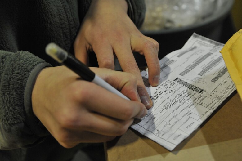 Airman 1st Class Bing Liu, 509th Logistics Readiness Squadron transportation management apprentice, marks a DD Form 1348-A1 at Whiteman Air Force Base, Mo., Feb. 5, 2014. The form ensures the document matches the information on the box. (U.S. Air Force photo by Airman 1st Class Keenan Berry/Released)