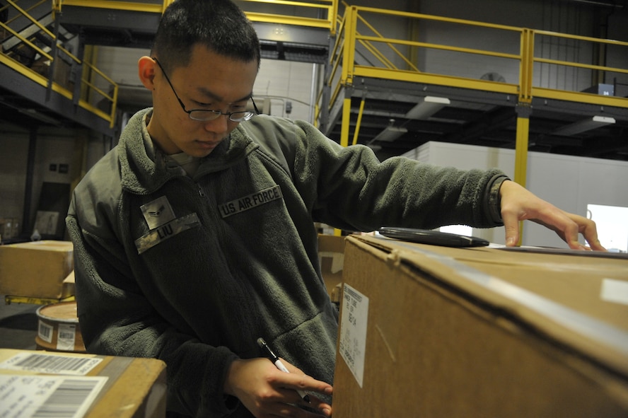 Airman 1st Class Bing Liu, 509th Logistics Readiness Squadron transportation management apprentice, inspects information on a box at Whiteman Air Force Base, Mo., Feb. 5, 2014. This process is done to confirm the information is accurate and the property is delivered to its destination. (U.S. Air Force photo by Airman 1st Class Keenan Berry/Released)