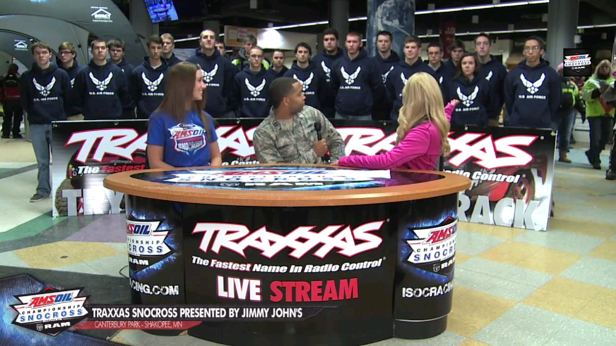 Carly Aplin, Traxxas Snocross host, praises future Air Force service members in an interview with Capt. Rudolph Bowen, 343rd Recruiting Squadron Operations Flight commander, in Shokopee, Minn., Jan. 4. Twenty-one Delayed Entry Program members took the oath of enlistment in front of a crowd of more than 12,000 at Canterbury Park's Traxxas Snocross. (Courtesy photo)