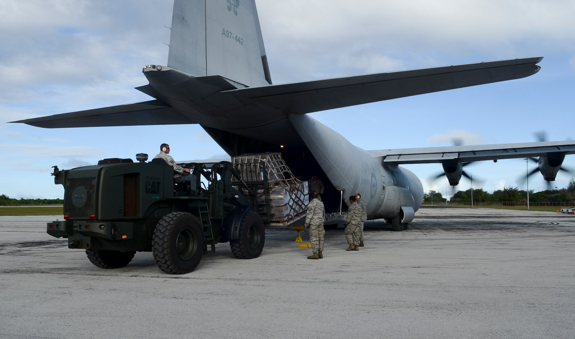 Airmen from the 36th Contingency Response Group offload a pallet of humanitarian aid supplies from a Royal Australian Air Force C-130 Hercules at the Rota International Airport, Feb. 19, 2014. Airmen from the U.S. Air Force, Japan Air Self-Defense Force and Royal Australian Air Force participating in Cope North, a multi-lateral exercise on Andersen Air Force Base, Guam, transitioned from the scenario-based humanitarian assistance and disaster relief training of the exercise on Tinian to humanitarian assistance of food and commodities to the citizens of Rota when Governor Eloy Inos declared Rota under a state of emergency following months without their regular resupply by sea. (U.S. Air Force photo by Senior Airman Marianique Santos/Released)