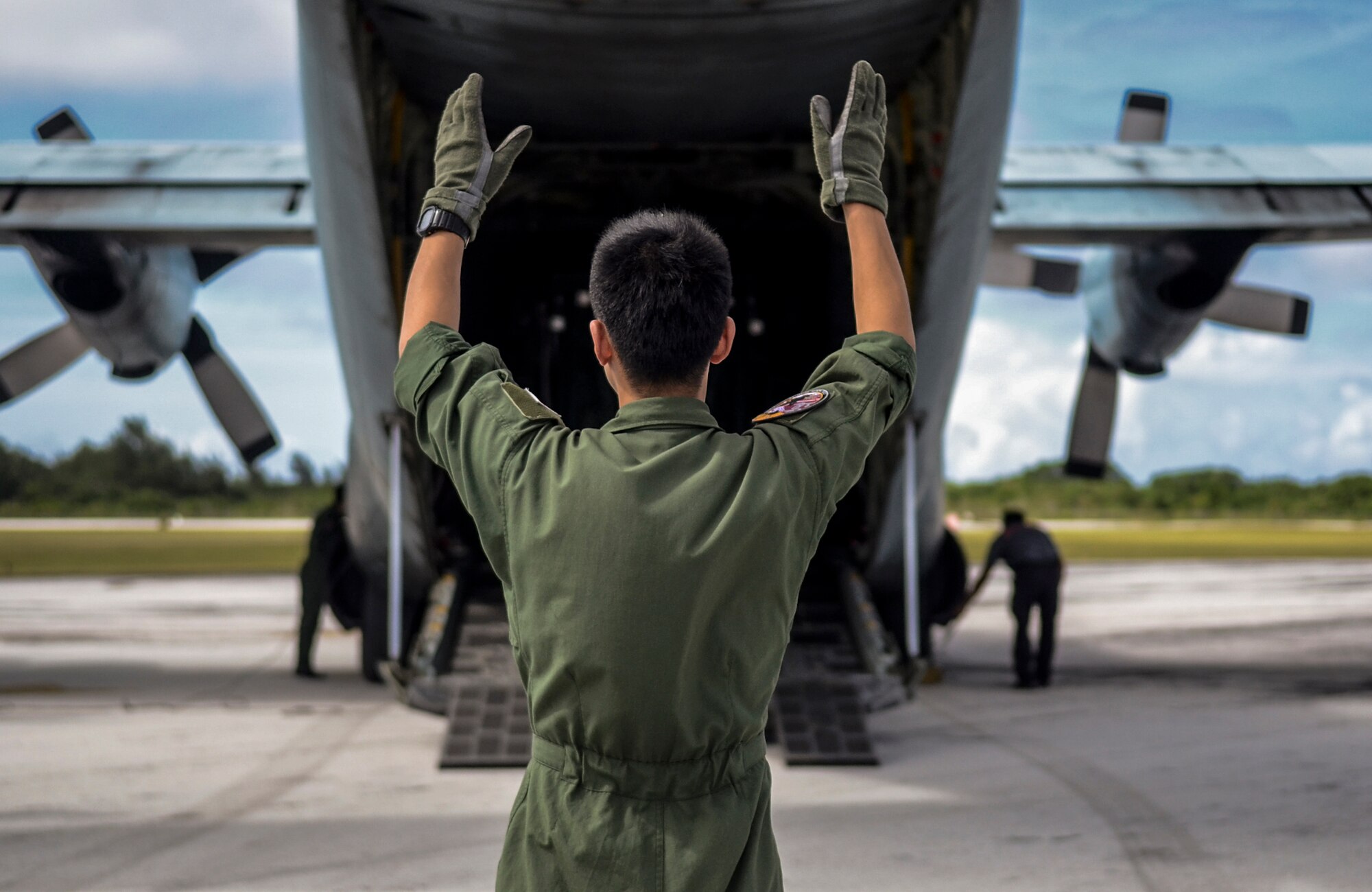 Japan Air Self-Defense Force Master Sgt. Hiroshi Moriyama, 401st Squadron Tactical Airlift Wing loadmaster, guides a forklift out of a C-130 Hercules at the Rota International Airport , Feb. 19, 2014. Airmen from the U.S. Air Force, Japan Air Self-Defense Force and Royal Australian Air Force participating in Cope North, a multi-lateral exercise on Andersen Air Force Base, Guam, transitioned from the scenario-based humanitarian assistance and disaster relief training of the exercise on Tinian to humanitarian assistance of food and commodities to the citizens of Rota when Governor Eloy Inos declared Rota under a state of emergency following months without their regular resupply by sea. (U.S. Air Force photo by Senior Airman Marianique Santos/Released)