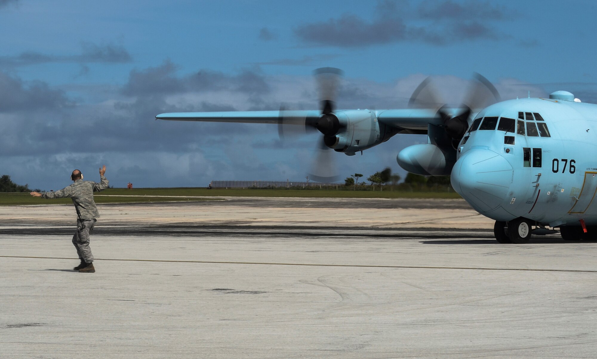 U.S. Air Force Tech. Sgt. Michael McCall, 36th Mobility Response Squadron crew chief, marshals a Japan Air Self-Defense Force C-130 Hercules at the Rota International Airport, Feb. 19, 2014. Airmen from the U.S. Air Force, Japan Air Self-Defense Force and Royal Australian Air Force participating in Cope North, a multi-lateral exercise on Andersen Air Force Base, Guam, transitioned from the scenario-based humanitarian assistance and disaster relief training of the exercise on Tinian to humanitarian assistance of food and commodities to the citizens of Rota when Governor Eloy Inos declared Rota under a state of emergency following months without their regular resupply by sea. (U.S. Air Force photo by Senior Airman Marianique Santos/Released)