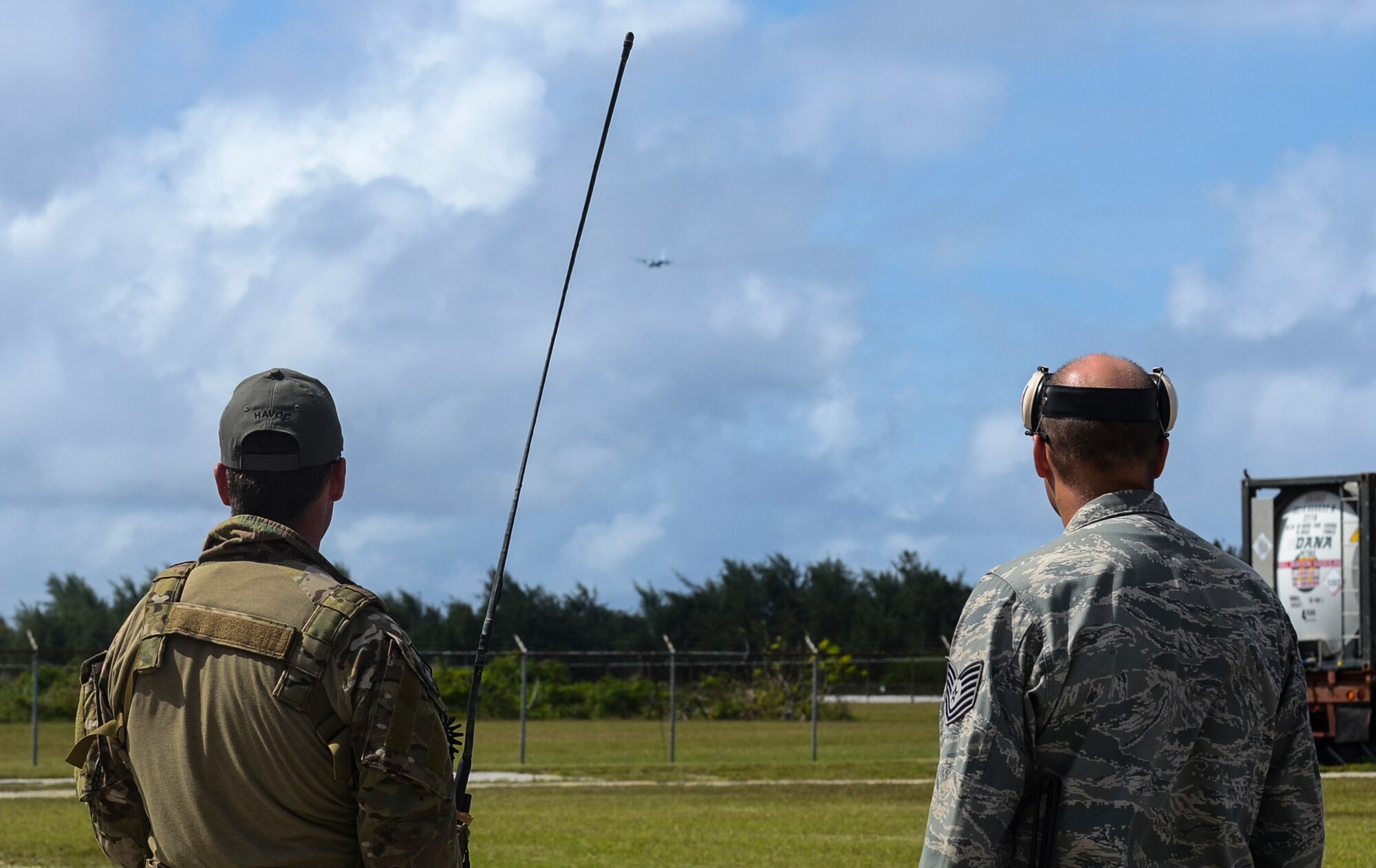 A Royal Australian Air force Combat Controller and Tech. Sgt. Michael McCall, 36th Mobility Response Squadron crew chief, communicate with an incoming Japan Air Self-Defense Force C-130 Hercules carrying equipment prior to landing at the Rota International Airport, Feb. 19, 2014. Airmen from the U.S. Air Force, Japan Air Self-Defense Force and Royal Australian Air Force participating in Cope North, a multi-lateral exercise on Andersen Air Force Base, Guam, transitioned from the scenario-based humanitarian assistance and disaster relief training of the exercise on Tinian to humanitarian assistance of food and commodities to the citizens of Rota when Governor Eloy Inos declared Rota under a state of emergency following months without their regular resupply by sea. (U.S. Air Force photo by Senior Airman Marianique Santos/Released)