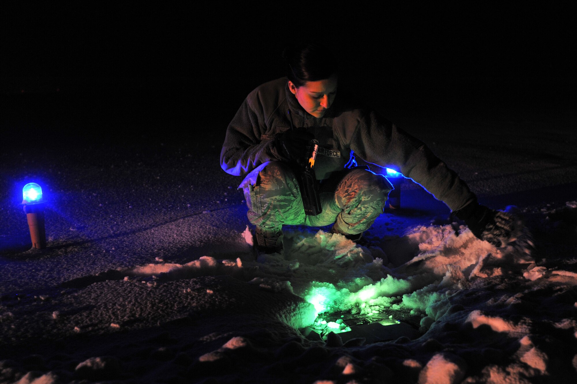 Senior Airman Alisha Laws, 92nd Operations Support Squadron airfield management shift lead, brushes snow from a light on the airfield after a storm Feb. 10, 2014, at Fairchild Air Field Base, Wash. The airfield management team conducts light checks every night to ensure all 2,168 lights are working on Fairchild’s airfield. (U.S. Air Force photo by Staff Sgt. Veronica Montes)