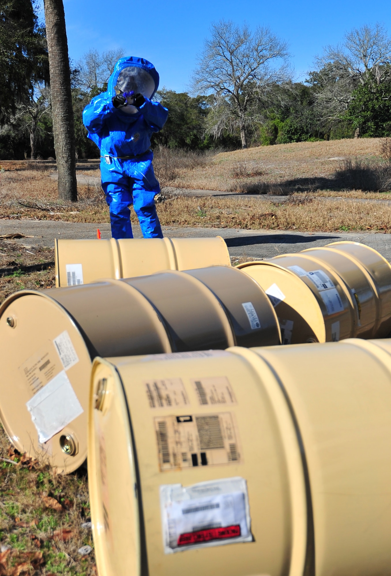 Senior Airman Daniel Muldowney, 325th Civil Engineering Squadron emergency management logistics journeyman, surveys leaking barrels in a simulated contaminated area Feb. 19 at the golf course. Muldowney participated in a week-long exercise that focuses on chemical, biological, radiological and nuclear defense. (U.S. Air Force photo by Airman 1st Class Sergio A. Gamboa)