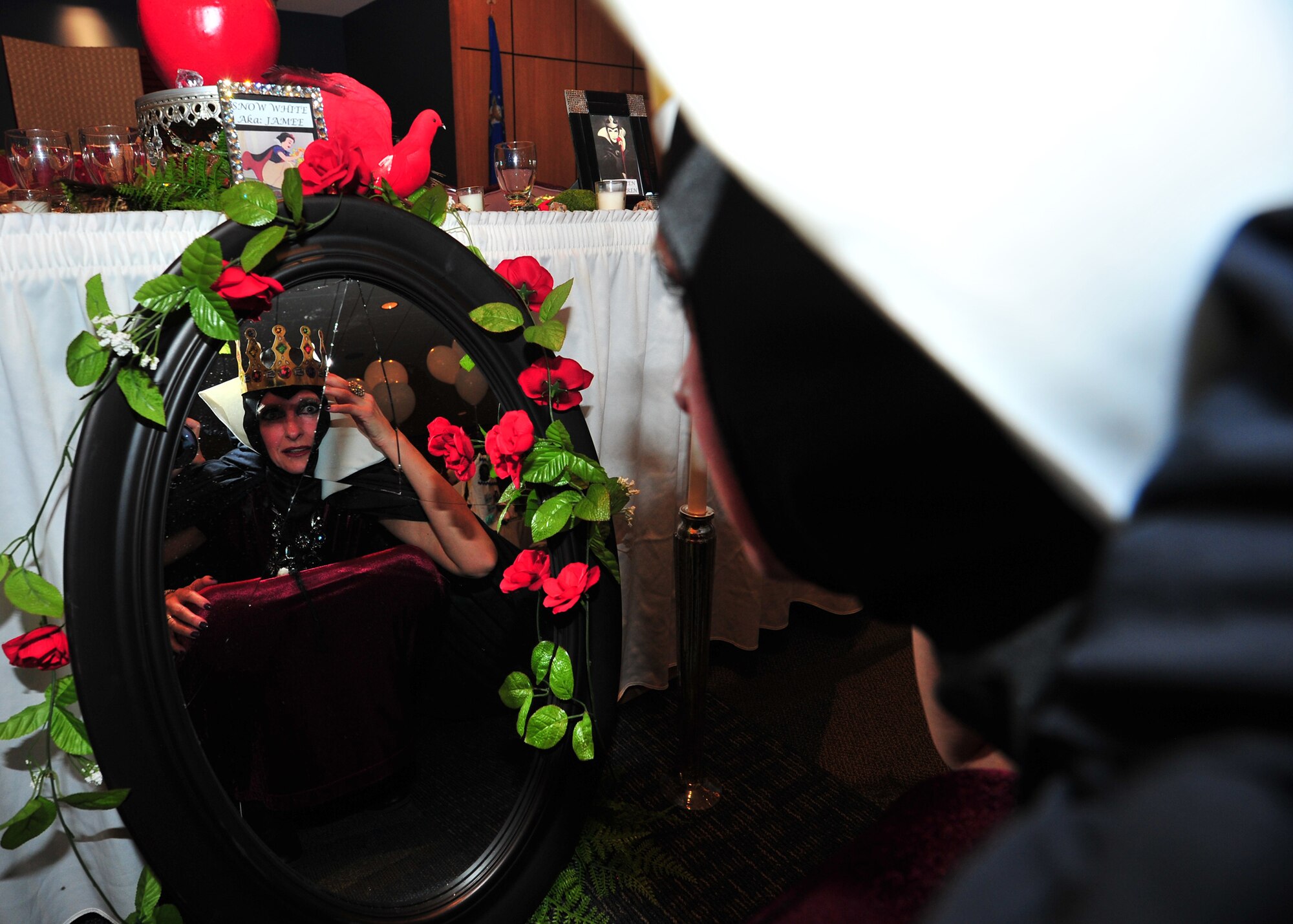 Mrs. Karen DeVite, wife of Chief Master Sgt. Raymond DeVite stares into a cracked mirror during the 1st Annual 325th Fighter Wing Spouse’s Dining-In Feb. 21 at the Horizon’s Activity Center. (U.S. Air Force photo by Airman 1st Class Sergio Gamboa)