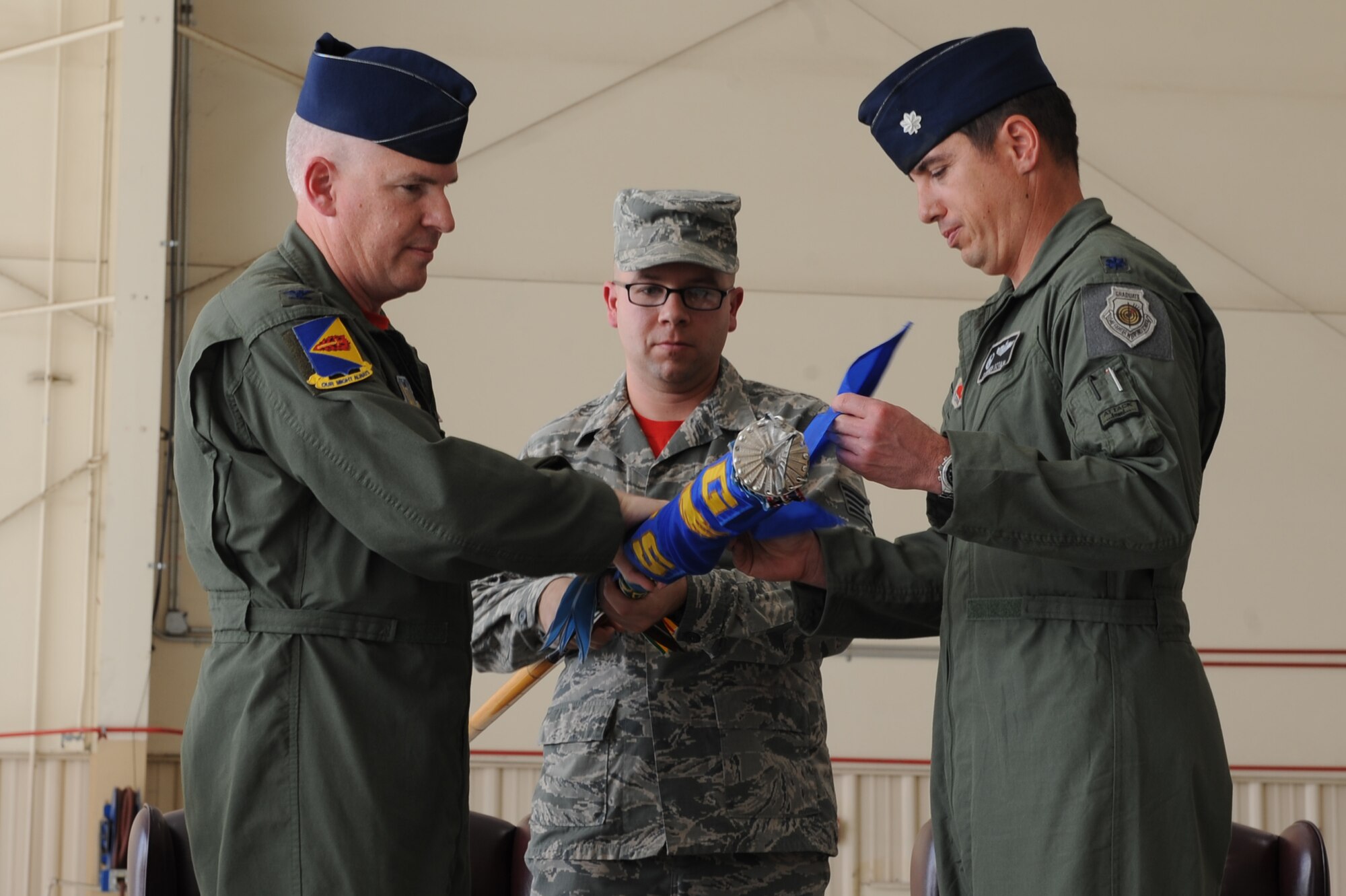 U.S. Air Force Col. Philip W. Wielhouwer, 355th Operations Group commander, and Lt. Col. Stephen C. Sztan, former 358th Fighter Squadron commander, roll up the 358th FS flag to finalize the squadron’s inactivation during a ceremony at Davis-Monthan Air Force Base, Ariz., Feb. 21, 2014. The squadron was inactivated due to the total force integration initiative. (U.S. Air Force photo by Airman 1st Class Chris Drzazgowski)
