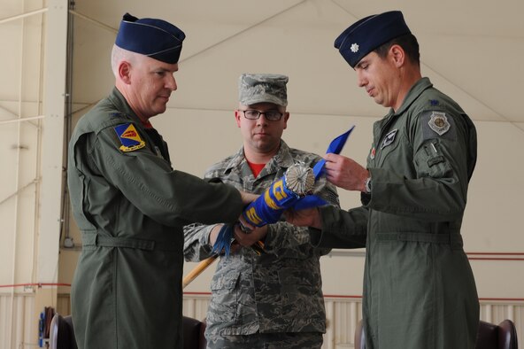 U.S. Air Force Col. Philip W. Wielhouwer, 355th Operations Group commander, and Lt. Col. Stephen C. Sztan, former 358th Fighter Squadron commander, roll up the 358th FS flag to finalize the squadron’s inactivation during a ceremony at Davis-Monthan Air Force Base, Ariz., Feb. 21, 2014. The squadron was inactivated due to the total force integration initiative. (U.S. Air Force photo by Airman 1st Class Chris Drzazgowski)