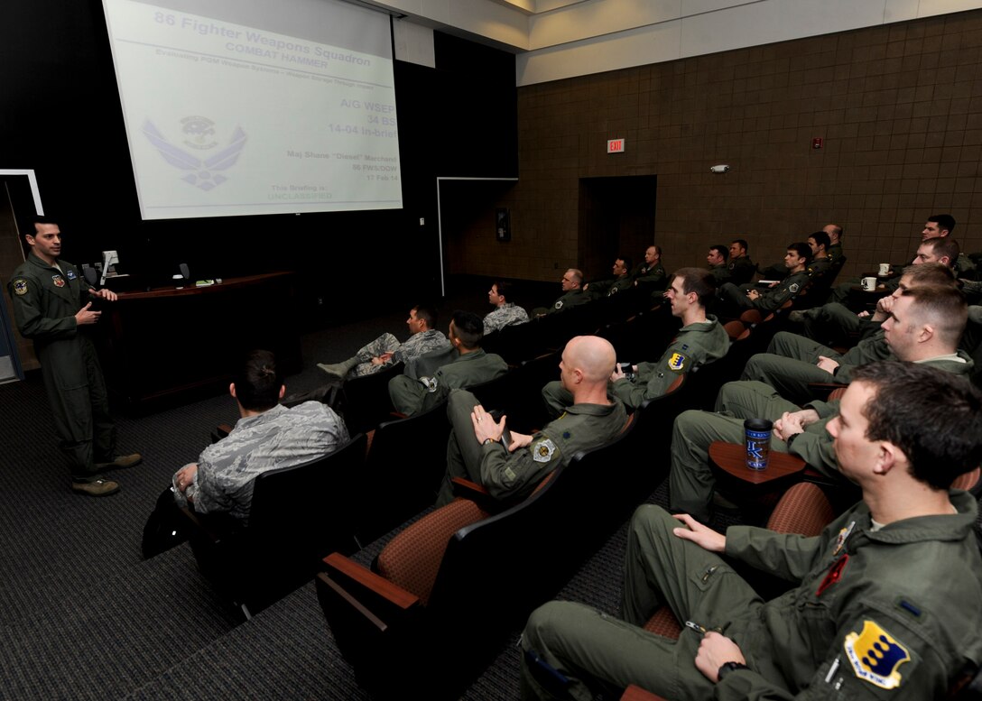 Maj. Shane Marchand, 86th Fighter Weapons Squadron project officer, briefs B-1 aviators from the 34th Bomb Squadron in preparation for the Combat Hammer exercise at Ellsworth Air Force Base, S.D., Feb. 17, 2014. As part of his role as combat hammer lead, Marchand traveled from Eglin AFB, Fla., to review the details and objectives of the exercise, emphasizing the importance of safety and remaining focused. (U.S. Air Force photo by Senior Airman Anania Tekurio/Released)