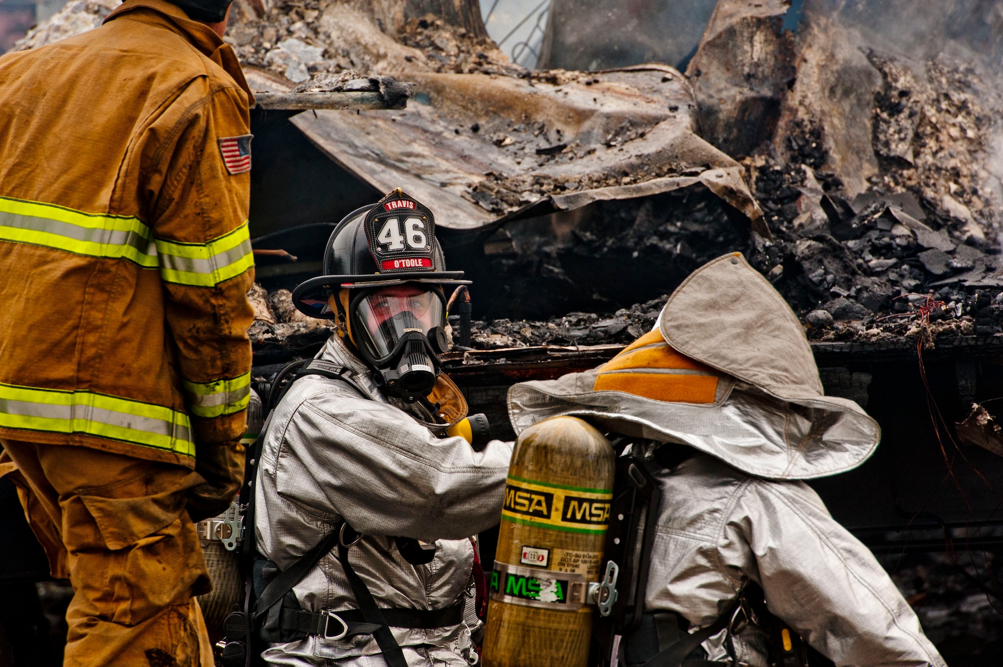 Airman 1st Class Patrick Otoole, 60th Civil Engineer Squadron firefighter and Christopher Muriset, 60th CES driver operator, perform salvage and overhaul operations at a burned-down trailer Feb. 18 in Vacaville, Calif. (U.S. Air Force photo/Tech. Sgt. Matthew Hannen)