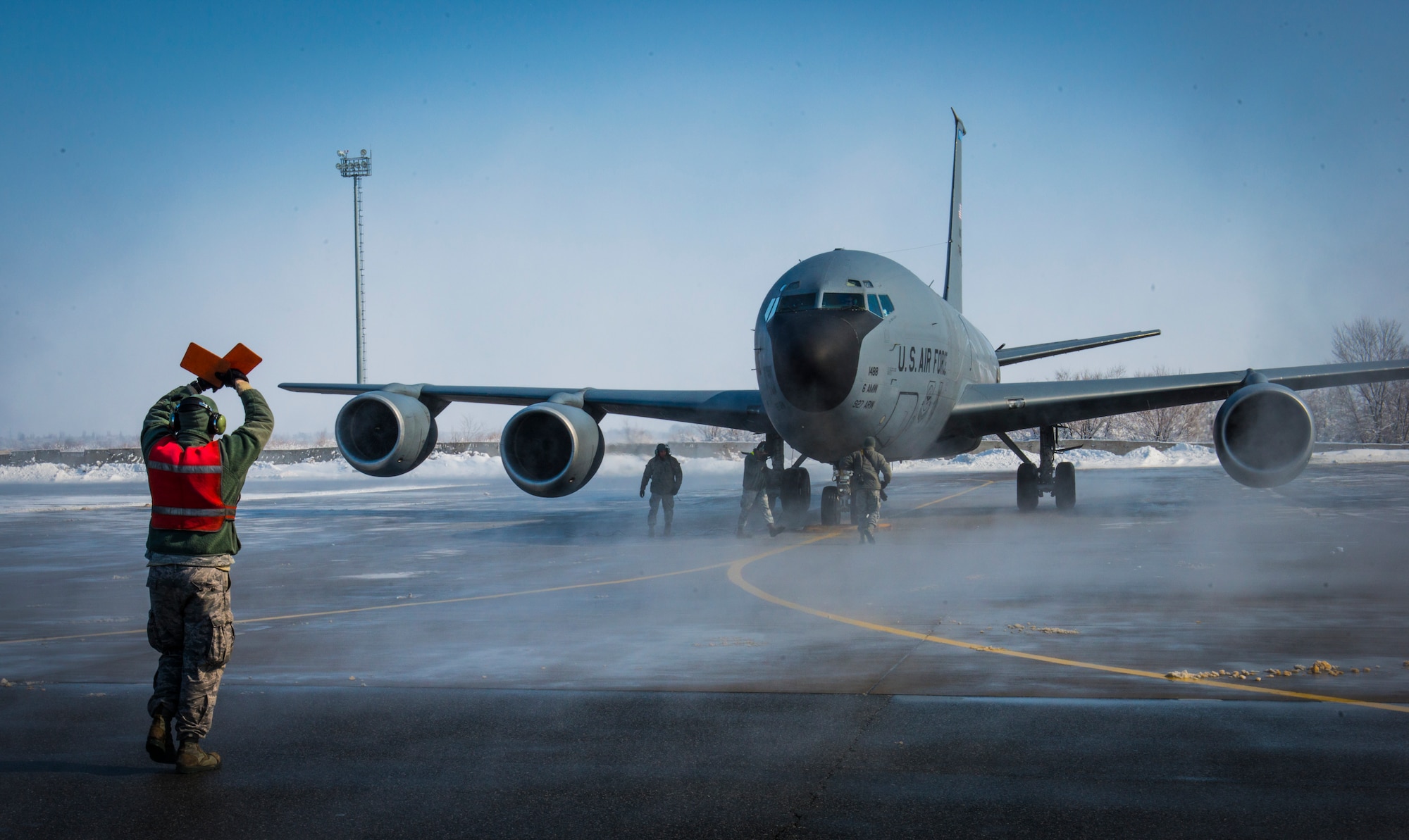 A crew chief with the 376th Expeditionary Aircraft Maintenance Squadron marshalls in a KC-135 Stratotanker after the a flight at Transit Center at Manas, Kyrgyzstan, Feb. 24, 2014. The flight was the last combat-refueling mission over Afghanistan from the TCM. (U.S. Air Force photo/Staff Sgt. Travis Edwards)