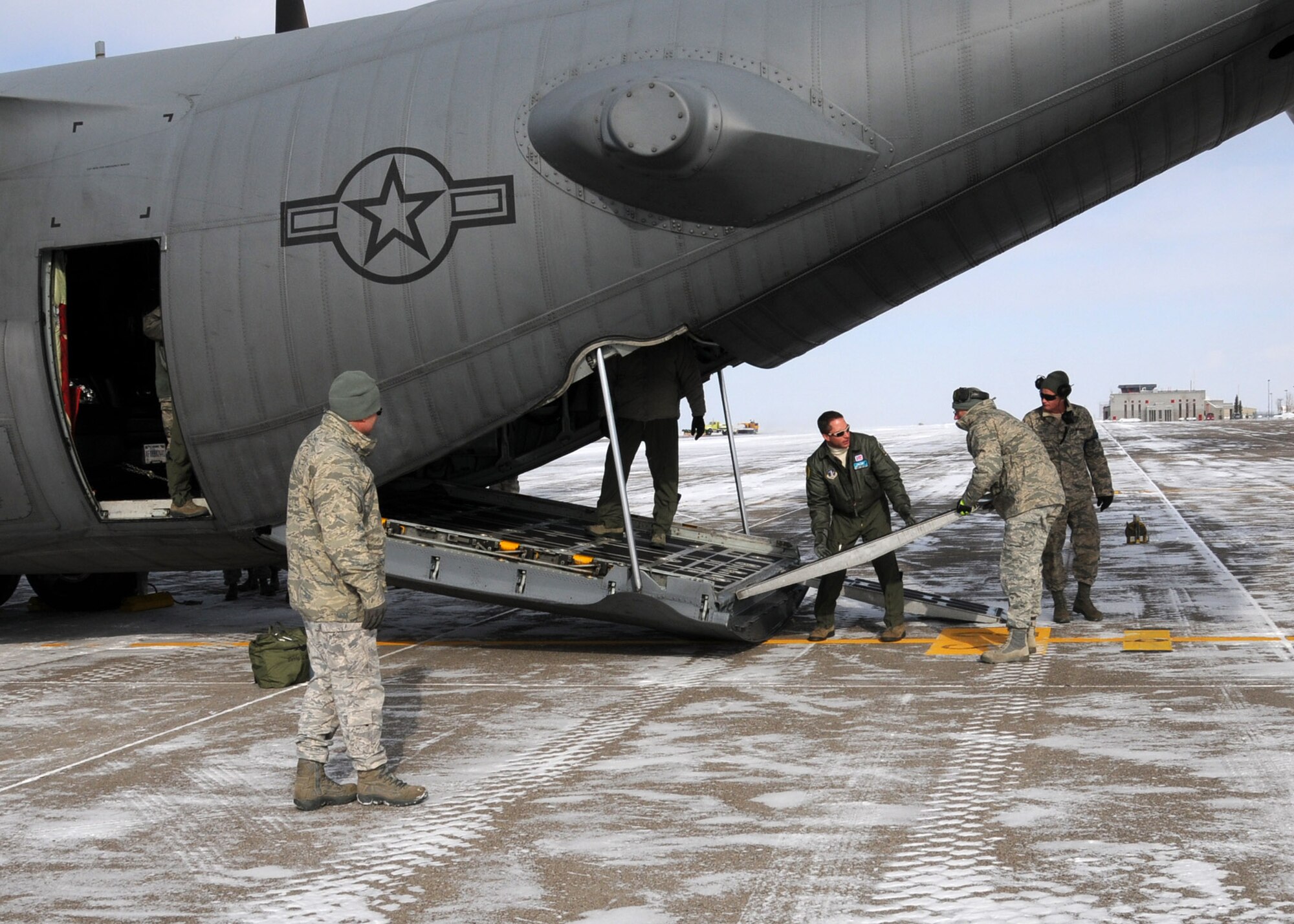 Members of the Wyoming Air National Guard set the ramps to unload a truck from a C-130 at the 120th Fighter Wing Feb. 8, 2014.  National Guard photo/2nd Lt. Robin Jirovsky.