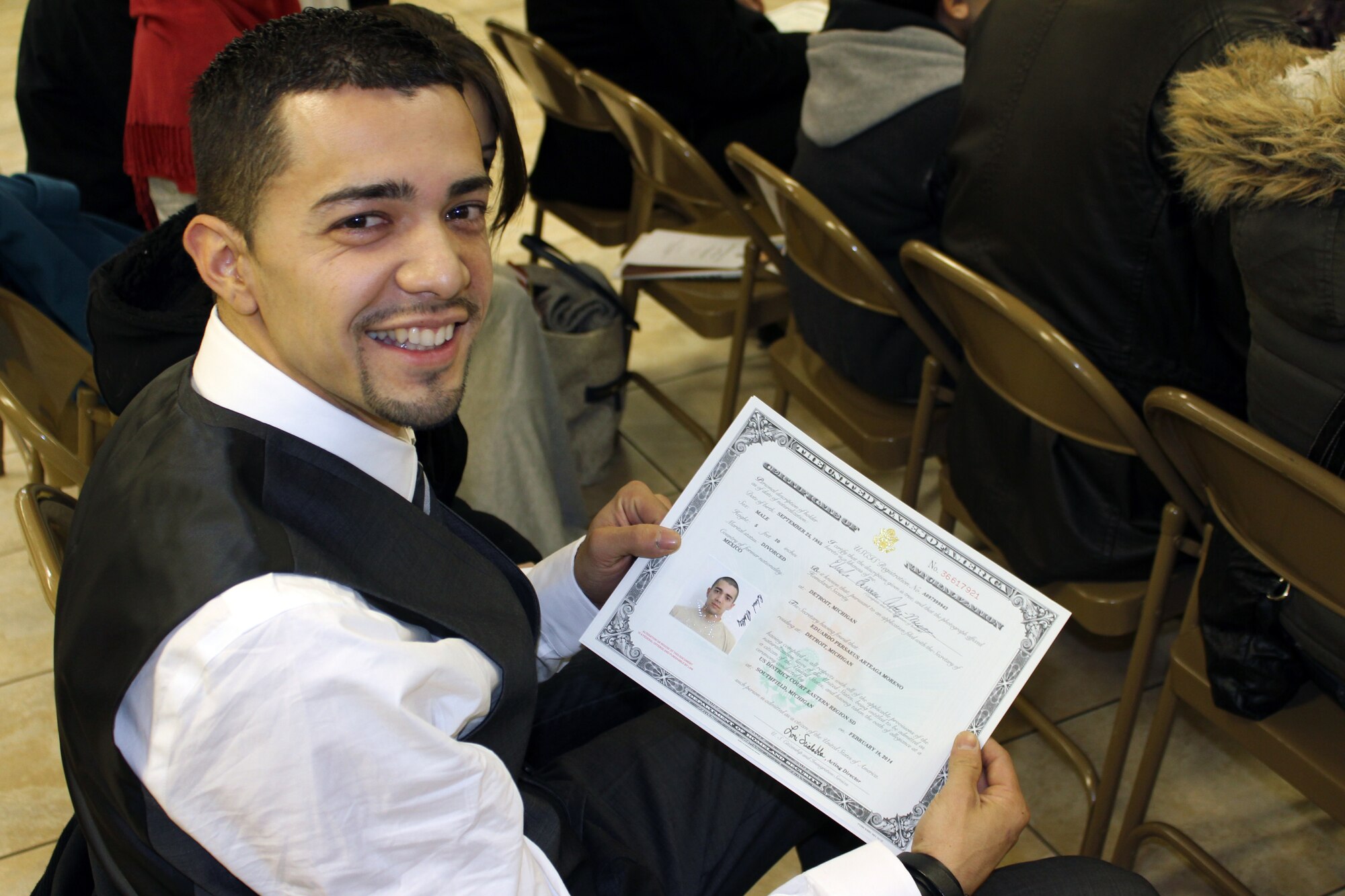 131218-Z-VA676-009 – Airman 1st Class Eduardo Arteaga shows off the certificate which declares him to be an American citizen, just moments after taking the Oath of Allegiance to the United States during a ceremony on Feb. 18, 2014. Arteaga recently joined the Michigan Air National Guard’s 127th Wing, which helped to facilitate his quest to become a U.S. citizen. The photo of Arteaga on the certificate was taken while Arteaga was at Basic Military Training. (U.S. Air National Guard photo by TSgt. Dan Heaton / Released)