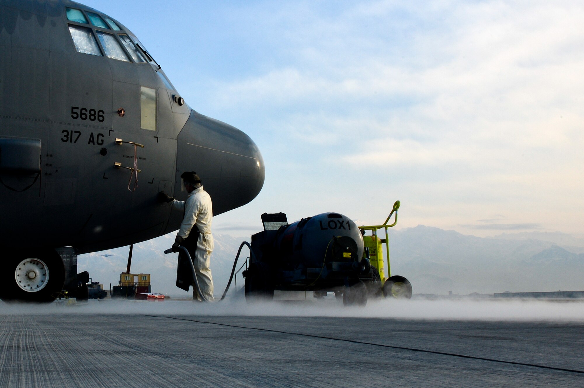 U.S. Air Force Senior Airman Matthew Martin, 455th Expeditionary Aircraft Maintenance Squadron C-130J Super Hercules crew chief, finishes servicing a C-130J with liquid oxygen at Bagram Airfield, Afghanistan, Feb. 21, 2014. LOX is oxygen in the form of liquid until it is converted into gas, and the process of servicing the aircraft is complete once there is a steady stream of LOX coming from the vent of the aircraft. (U.S. Air Force photo by Senior Airman Kayla Newman/Released)