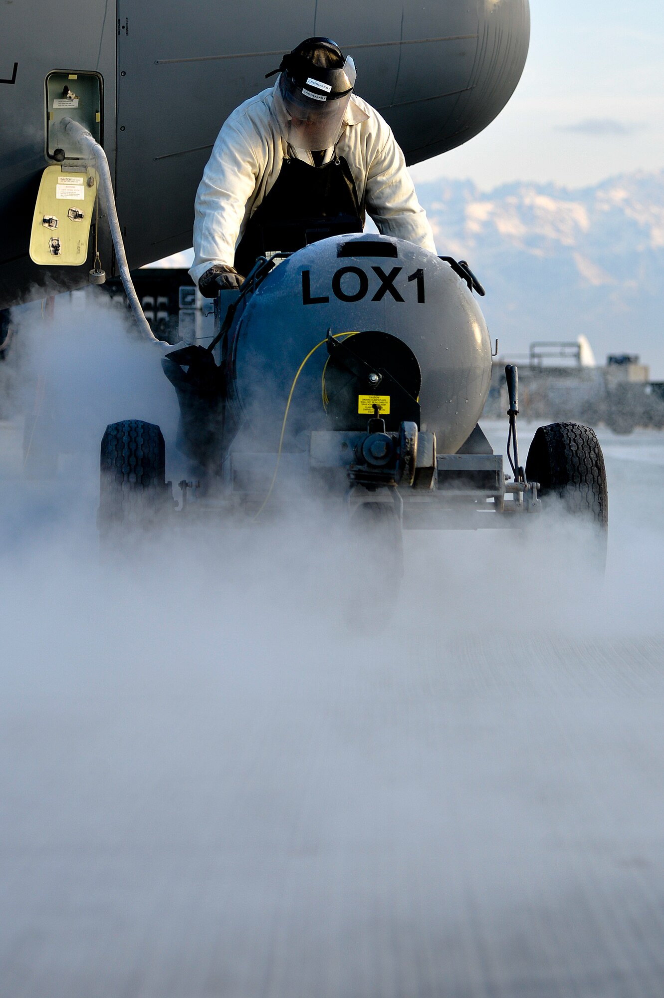 U.S. Air Force Senior Airman Matthew Martin, 455th Expeditionary Aircraft Maintenance Squadron C-130J Super Hercules crew chief, services a C-130J with liquid oxygen at Bagram Airfield, Afghanistan, Feb. 21, 2014. LOX is oxygen in the form of liquid until it is converted into gas, which allows pilots, aircrew members and everyone on board the aircraft the ability to breathe while in the air. (U.S. Air Force photo by Senior Airman Kayla Newman/Released)