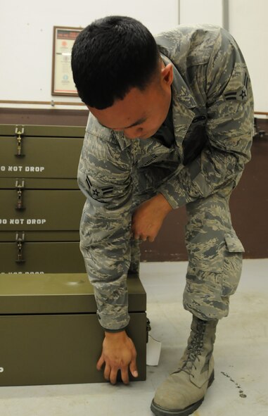 Airman 1st Class Christian Afaisen, 86th Munitions Squadron conventional maintenance crew member, stacks boxes to prepare for a 100 percent accountability inspection Feb. 13, 2014, Ramstein Air Base, Germany. The conventional maintenance shop is in charge of maintaining shelf and service life on countermeasures used in C-130J Super Hercules. They also perform storage monitoring inspections on in-line items kept within the munitions storage area. (U.S. Air Force photo/Airman 1st Class Holly Mansfield)