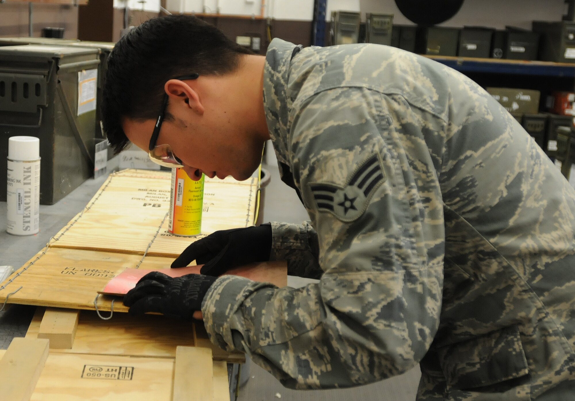 Senior Airman Bryan Sandt, 86th Munitions Squadron maintenance crew chief, spray paints numbers on a box to prepare for a 100 percent accountability inspection Feb. 13, 2014, Ramstein Air Base, Germany. The conventional maintenance shop is in charge of maintaining shelf and service life on countermeasures used in C-130J Super Hercules. They also perform storage monitoring inspections on in-line items kept within the munitions storage area. (U.S. Air Force photo/Airman 1st Class Holly Mansfield)