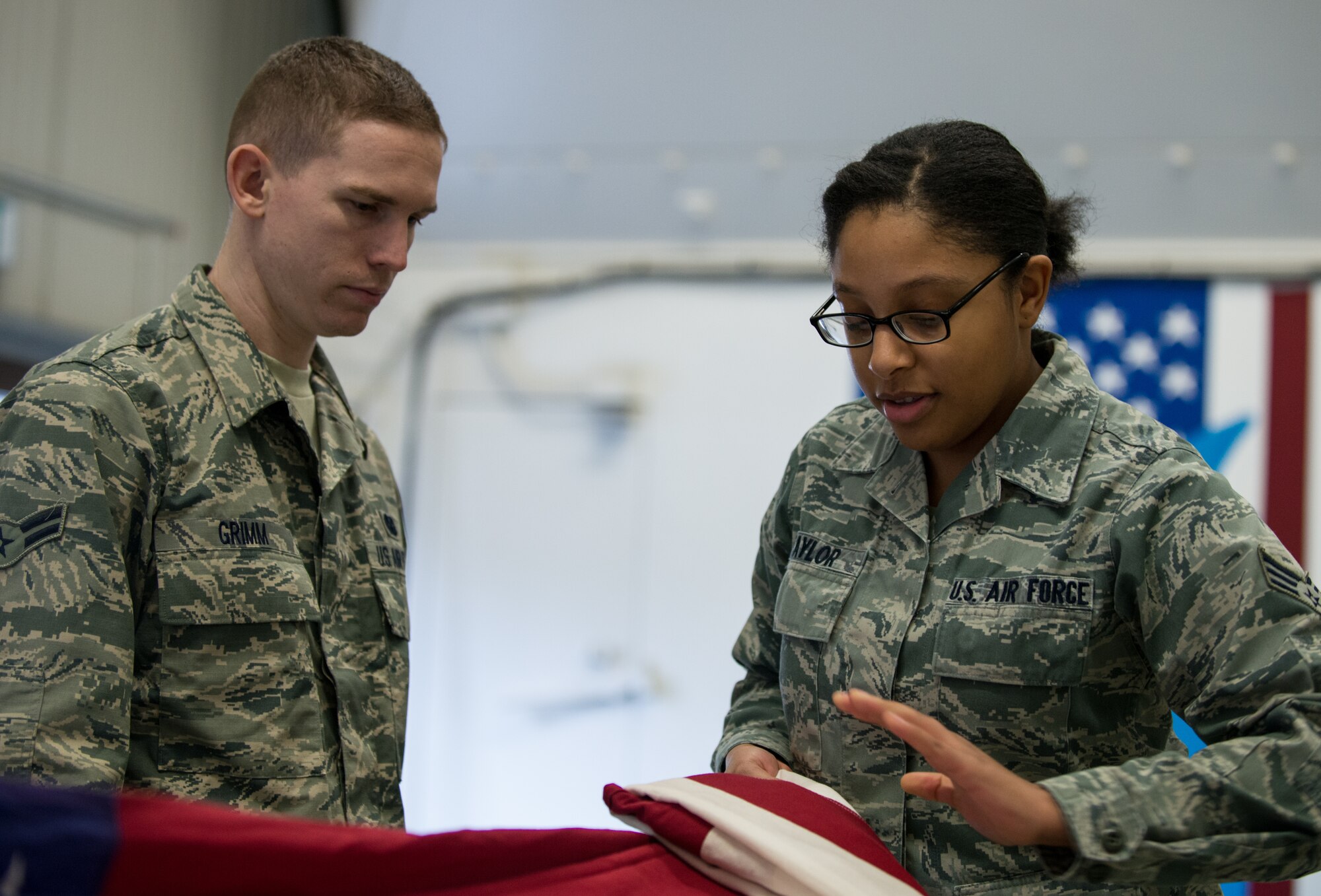 Senior Airman Chardonnay Taylor, 1st Air and Space Communications Operations Squadron honor guardsman, teaches Airman 1st Class Kevin Grimm, 86th Vehicle Readiness Squadron honor guardsman, how to correctly fold an American flag Feb. 19, 2014, Ramstein Air Base, Germany. Taylor has been a part of the base honor guard for two years and has completed 57 ceremonies. (U.S. Air Force photo/Senior Airman Jonathan Stefanko)