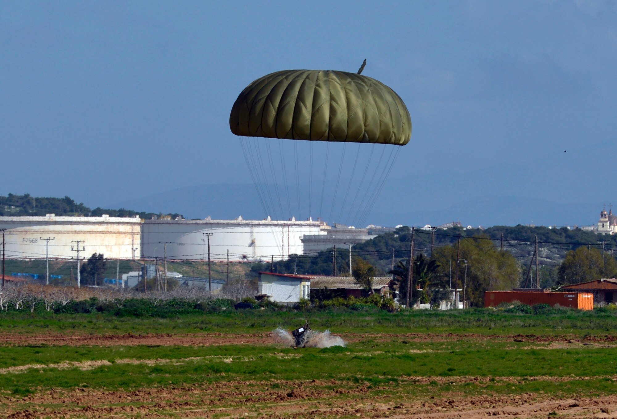 A Greek cargo pallet splashes down in the mud after being dropped off the back of a U.S. Air Force C-130J Super Hercules during Stolen Cerberus, a two-week flying, training deployment designed to incorporate various training methods in order to maintain proficiency during deployed operations and increase interoperability with the Hellenic Air Force. The mission, which took place Feb. 2 to 14, involved more than 200 U.S. and Greek service members flying day and night operations. (U.S. Air Force photo/Staff Sgt. Kris Levasseur)