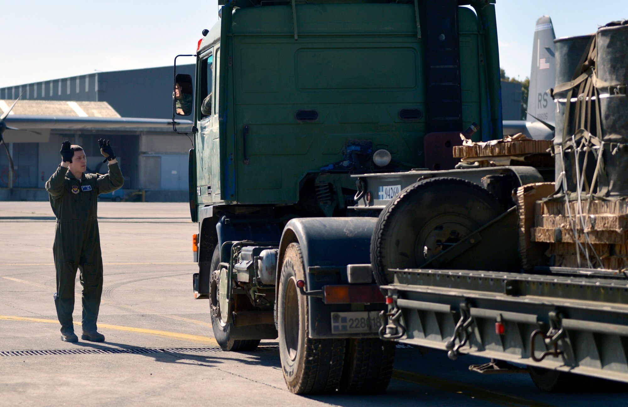 Tech. Sgt. James Moenning, 37th Airlift Squadron loadmaster, guides a Greek service member as he backs up a truck to load cargo on a Ramstein C-130J Super Hercules during Stolen Cerberus, a two-week flying, training deployment designed to incorporate various training methods in order to maintain proficiency during deployed operations and increase interoperability with the Hellenic Air Force.  The mission, which took place Feb. 2 to 14, involved more than 200 U.S. and Greek service members flying day and night operations. (U.S. Air Force photo/Staff Sgt. Kris Levasseur)
