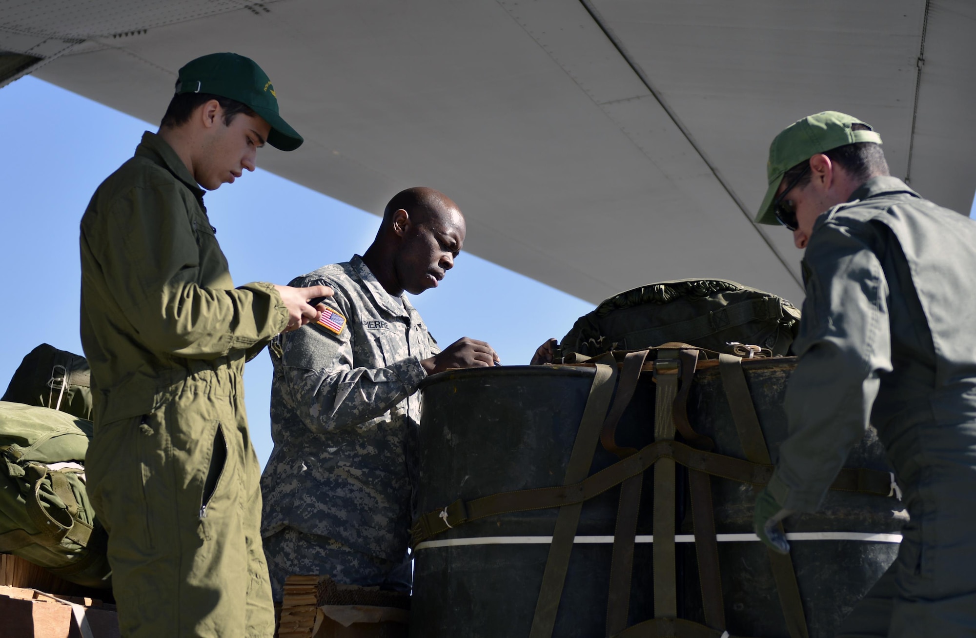 Cpl. Aldeon Pierre, 5th Quartermaster Company, checks an airdrop bundle with two Greek service members during Stolen Cerberus, a two-week flying, training deployment designed to incorporate various training methods in order to maintain proficiency during deployed operations and increase interoperability with the Hellenic Air Force, Feb. 2 to 14. The combined training also incorporated several support elements, such as aircrew flight equipment, joint airdrop inspection and security forces. (U.S. Air Force photo/Staff Sgt. Kris Levasseur)