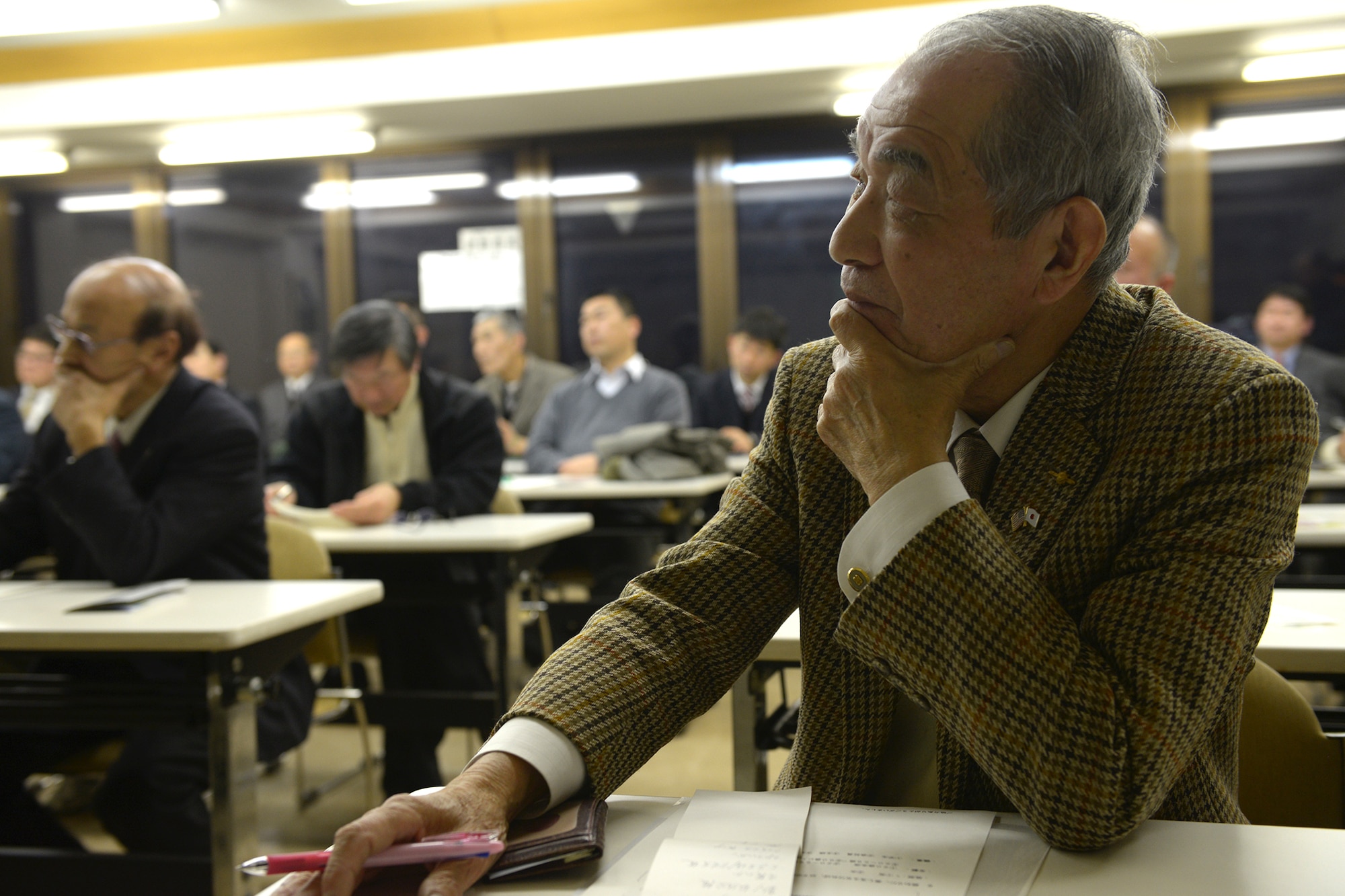 Fumio Sawanobori, president of the Musahimurayama Yokota Friendship Club, listens to briefings from U.S. Air Force officers from Yokota Air Base, Japan, in Musashimurayama, Japan, Feb. 21, 2014. This was the first local defense seminar given by Yokota and hosted by the North Kanto Defense Bureau, and was held to strengthen bonds between Yokota and the local community. (U.S. Air Force photo by Airman 1st Class David Danford/Released)