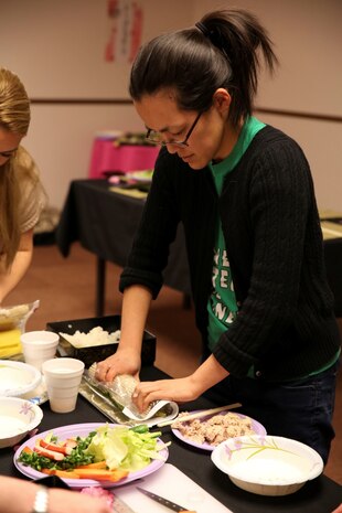 Kieu Garcia, personal financial manager with Marine Corps Community Services, makes Norimaki sushi during a sushi making class hosted by the Marauders Spouse Club, Feb. 22, 2014, aboard Marine Corps Air Station Iwakuni, Japan. The Marauders Spouse Club offered the class to spouses and guests from all units aboard station.