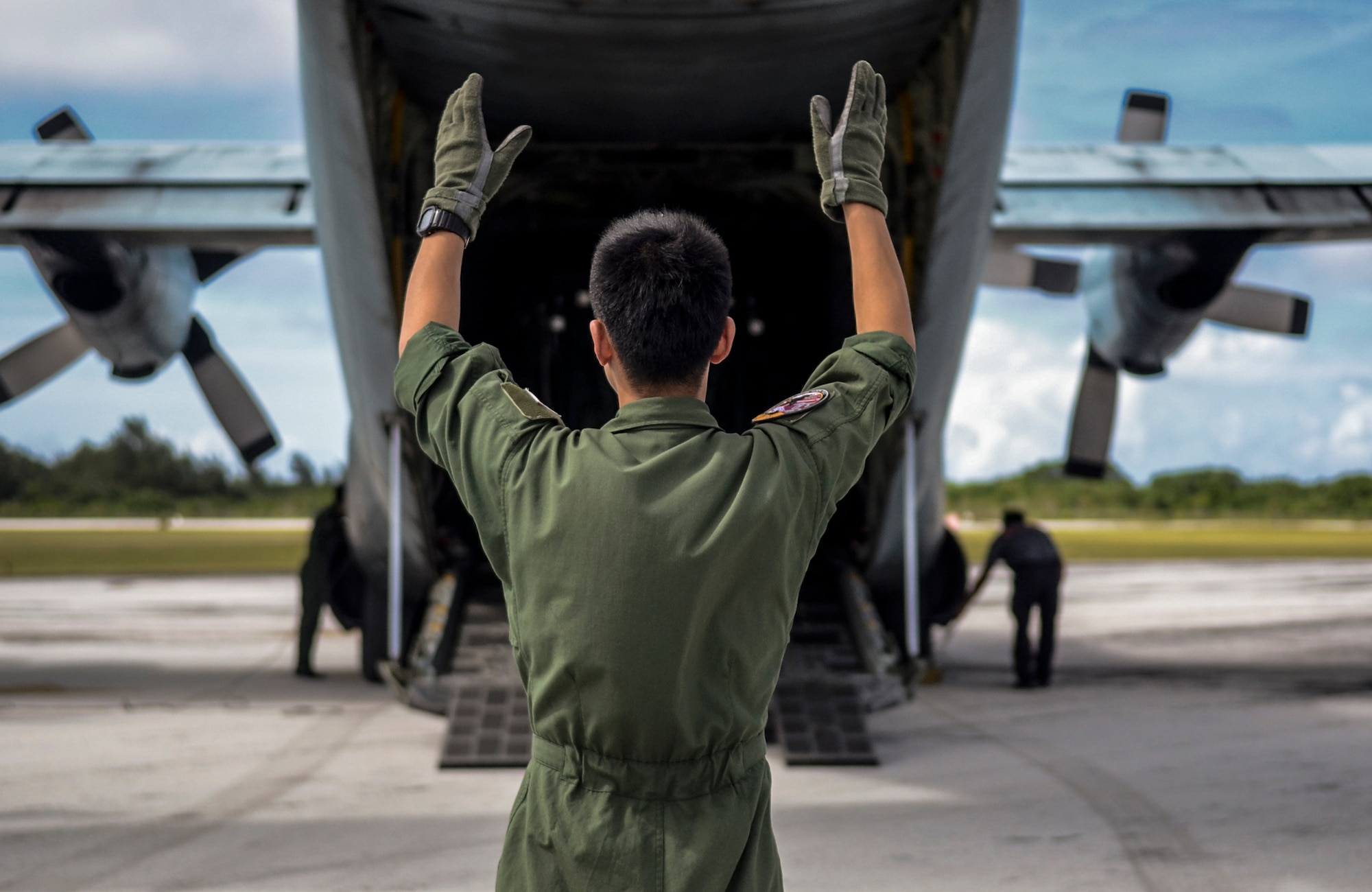 Japan Air Self-Defense Force Master Sgt. Hiroshi Moriyama guides a forklift out of a C-130 Hercules Feb. 19, 2014, at the Rota International Airport. Airmen from the Air Force, Japan Air Self-Defense Force and Royal Australian air force participating in Cope North, a multi-lateral exercise on Andersen Air Force Base, Guam. The exercise transitioned from a scenario-based humanitarian assistance and disaster relief training to real world humanitarian assistance of food and commodities to the citizens of Rota when it was declared to be under a state of emergency following months without their regular resupply by sea. Moriyama is a 401st Squadron Tactical Airlift Wing loadmaster. (U.S. Air Force photo/Senior Airman Marianique Santos)  