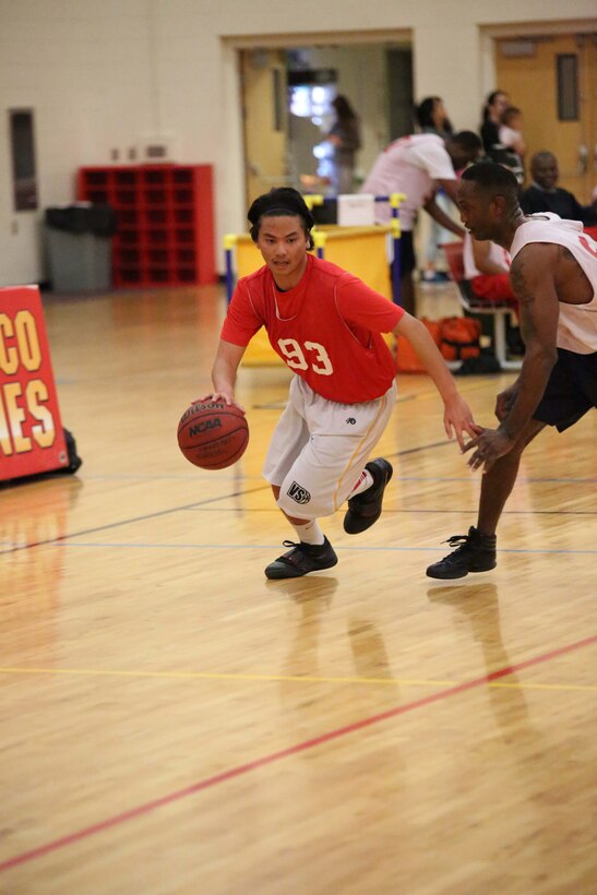 A Marine Corps Embassy Security Guard basketball team member dribbles the ball during a game against the Marine Corps Systems Command team at the Barber Physical Activities Center on Feb. 19, 2014. MCESG lost the game 27-68.
