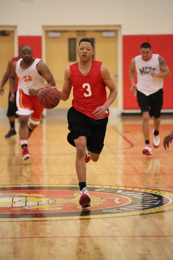 Billy Dixson, Marine Corps Embassy Security Guard team member, dribbles a ball against the Marine Corps Systems Command team at the Barber Physical Activities Center on Feb. 19, 2014. MCESG lost the game 27-68. 