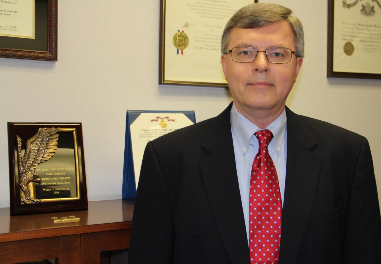 Southwestern Division Deputy Counsel Walter J. Skierski, Jr., stands next to the Corps of Engineers 2013 Bert Pettinato Award for Public Service.




