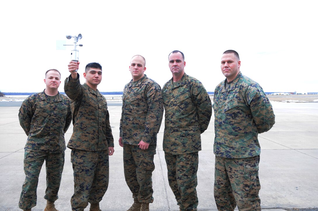 Five of the seven Marines responsible for forecasting the weather for Quantico Marine Corps Air Facility are, from left, Chief Warrant Officer 3 James Mayfield, Cpl. Angel Guajardo, Lance Cpl. Blake Cartin, Gunnery Sgt. Jimmy Shields and Staff Sgt. Chase Tillman, shown on the air field Feb. 20. The pictured weathervane, which measures wind speed and direction, is among their simpler tools. 