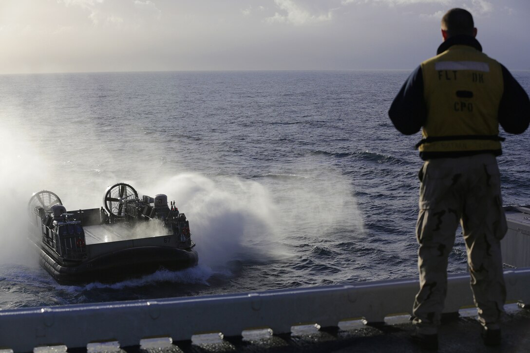 A U.S. Navy Sailor stands watch as a landing craft, air cushion with Assault Craft Unit 4 returns to the USS Bataan (LHD 5), at sea, Feb. 24, 2014, during Spanish Amphibious Bilateral Exercise (PHIBLEX) 2014. U.S. Marines and Sailors with the 22nd Marine Expeditionary Unit (MEU) are working alongside Portuguese Marines and Spanish Marines in order to build global maritime partnerships with European nations and improve maritime safety and security. The MEU is deployed to the U.S. 6th Fleet area of responsibility with the Bataan Amphibious Ready Group as a sea-based, expeditionary crisis response force capable of conducting amphibious missions across the full range of military operations. (U.S. Marine Corps photo by GySgt Freddy G. Cantu/Released)