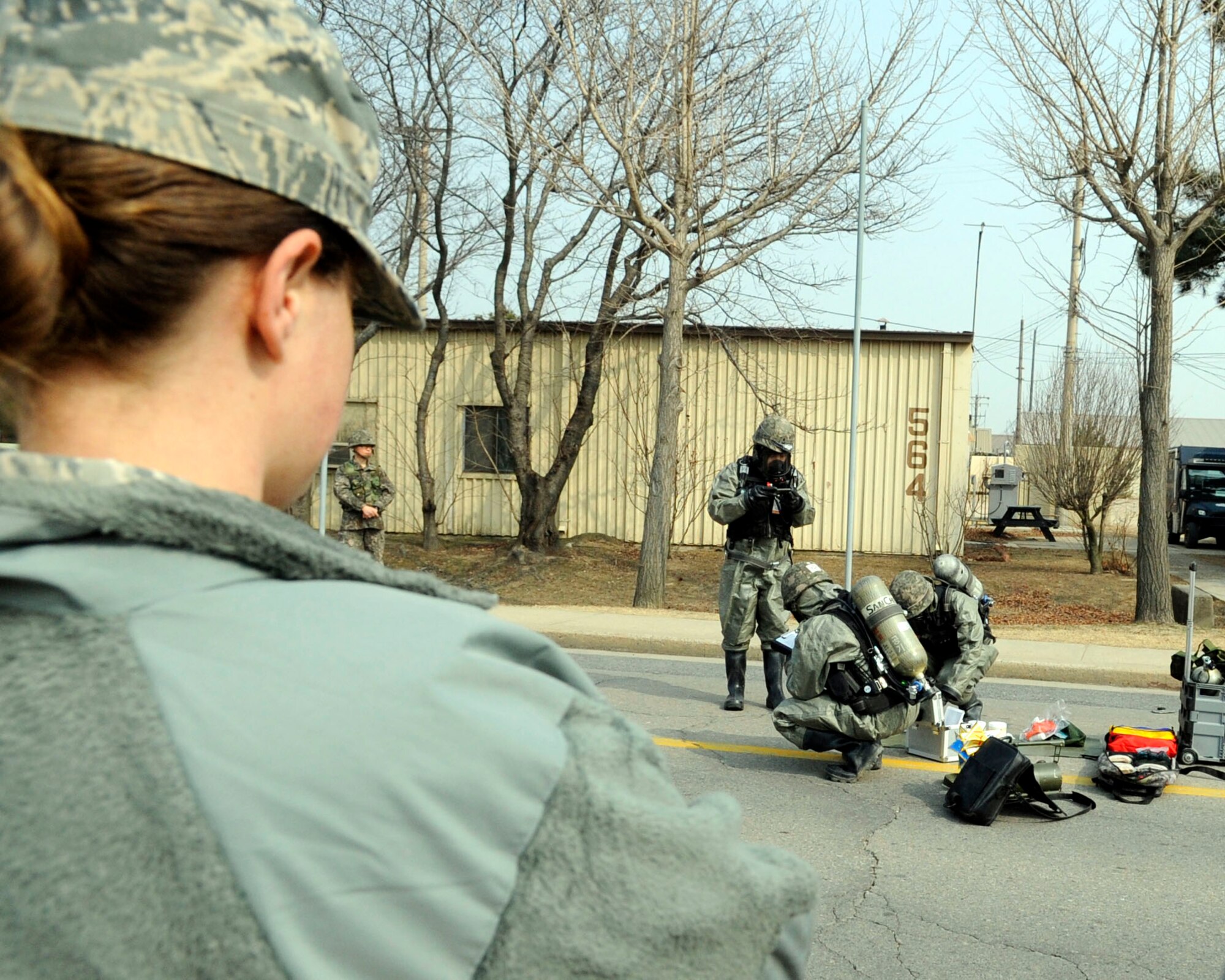 Staff Sgt. Lauren Greenwald, 8th Civil Engineer Squadron emergency management journeyman, observes 2nd Lt. Choi Ho Young, Tech. Sgt. You Sung Chul and Spc. Kim Hui Gon, all assigned to the Republic of Korea 35th army division, while they demonstrate their chemical attack response capabilities during a chemical, biological, radiological and nuclear training scenario, Feb. 24, 2014 at Kunsan Air Base, Republic of Korea. The CBRN unit had to call in global positioning system coordinates before determining the type of contamination found. (U.S. Air Force photo by Staff Sgt. Jessica Haas/Released)
