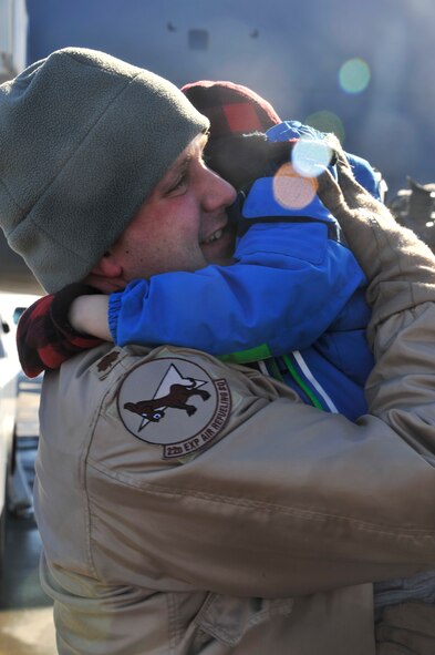Maj. Christopher Johnson, a 93rd Air Refueling Squadron KC-135 Stratotanker pilot, hugs his son at Fairchild Air Force Base, Wash., Feb. 25, 2014. Johnson was a member of one of three crews returning to Fairchild from the Transit Center at Manas, Kyrgystan, for the last time. (U.S. Air Force photo/Senior Airman Mary O'Dell)