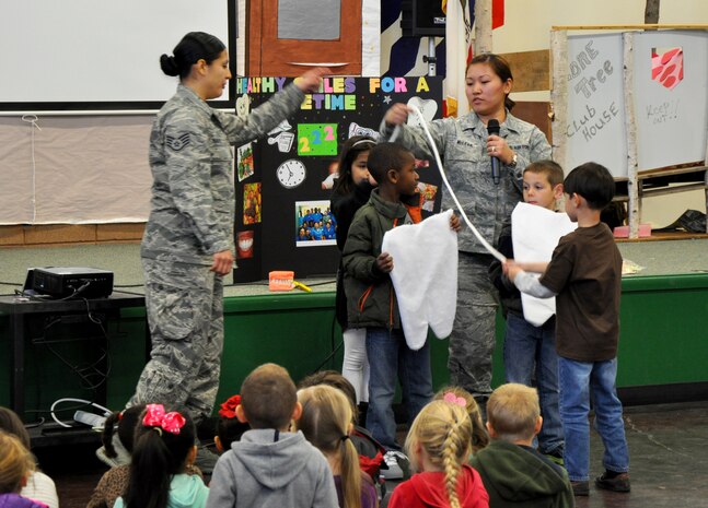 Staff Sgt. Rosario Warren (left) and Senior Airman Jennifer McLear, 9th Aerospace Medicine Squadron dental assistants, demonstrate how to properly floss teeth to students of Lone Tree Elementary School at Beale Air Force Base, Calif., Feb. 20, 2014. (U.S. Air Force photo by Staff Sgt. Robert M. Trujillo/Released)