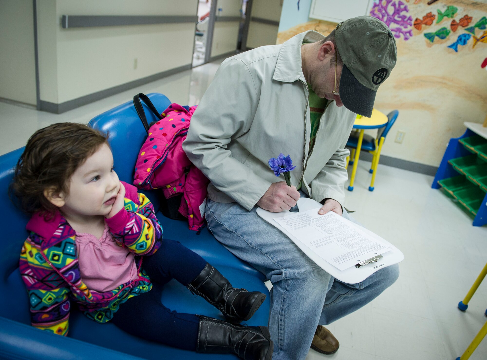 YOKOTA AIR BASE, Japan -- Tech. Sgt. Scott Fourre 374th Operations Squadron, Fills out patient paperwork for his daughter Violet, age three, during the Little Teeth-Big Smiles event at Yokota Air Base, Japan, Feb. 22, 2014. As part of National Children's Dental Health Month, the 374 Dental Squadron hosted walk-in clinic for children, including dental examinations, cleanings and education services. (U.S. Air Force photo by Staff Sgt. Andrea Salazar/Released)
