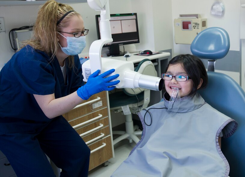YOKOTA AIR BASE, Japan -- Senior Airman Christa Cooper, 374th Dental Squadron dental assistant, prepares an X-ray dental exam for Andrea Pearson, age six, at Yokota Air Base, Japan, Feb. 22, 2014. During the event, children received examinations, cleanings, x-rays and educational services. (U.S. Air Force photo by Staff Sgt. Andrea Salazar/Released)