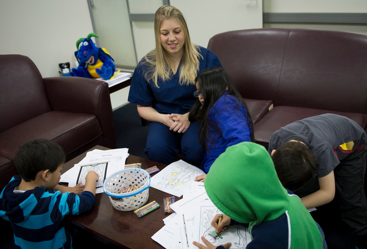 YOKOTA AIR BASE, Japan -- Stephanie Osbourne, 374th Dental Squadron volunteer, assists children during the event Little Teeth-Big Smiles, at Yokota Air Base, Japan, Feb. 2, 2014. Members from the Yokota Dental Clinic invited children, up to 10 years old, to attend a walk-in dental clinic. (U.S. Air Force photo by Staff Sgt. Andrea Salazar/Released)