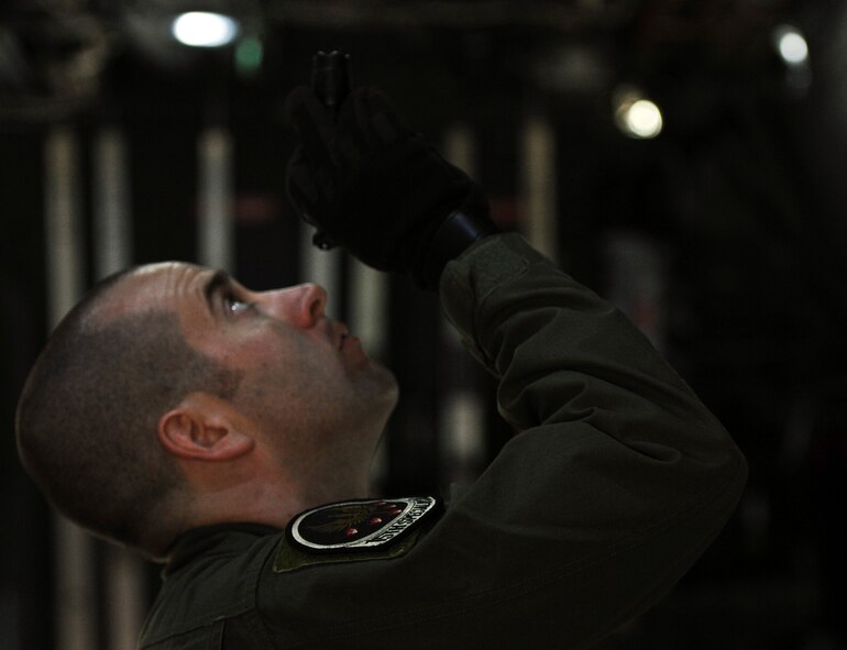 Staff Sgt. Kevin Reilly, 15th Special Operations Squadron flight engineer, uses a flashlight to inspect a MC-130H Combat Talon II on the flightline at Hurlburt Field, Fla., Feb. 19, 2014. (U.S. Air Force photo/Senior Airman Michelle Vickers)