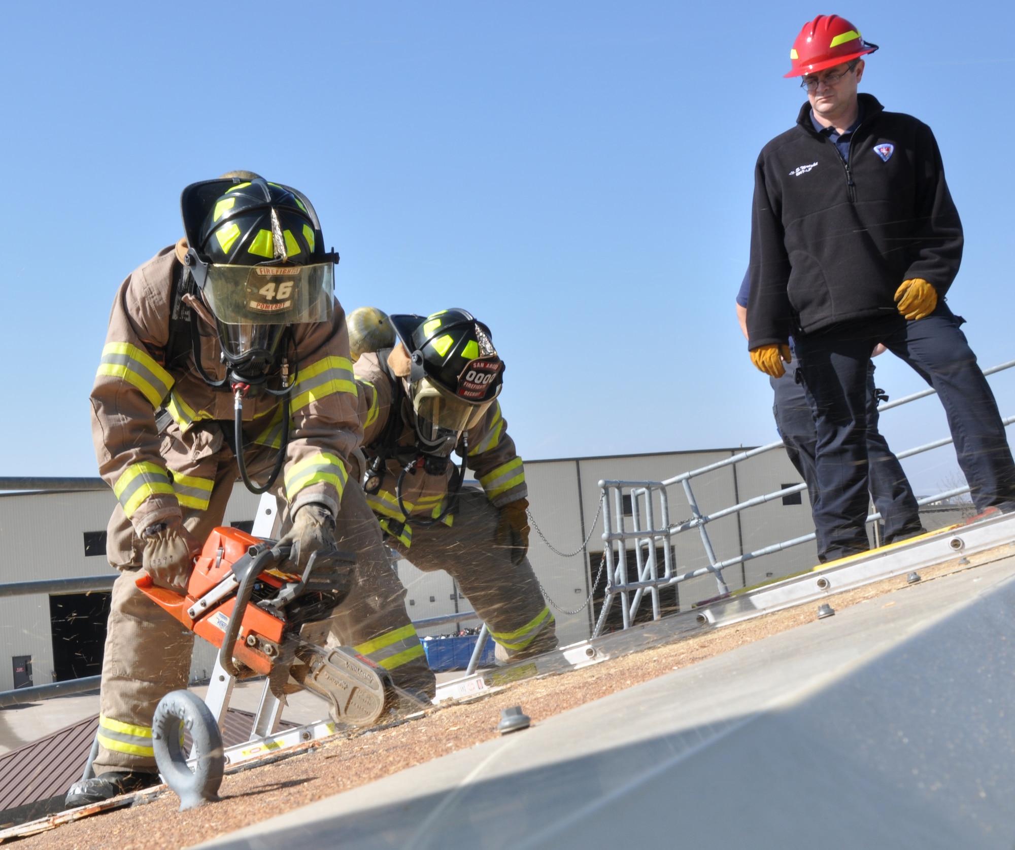 GOODFELLOW AIR FORCE BASE, Texas – Brice Bell, San Angelo Fire Department recruit, cuts a hole in plywood during tactical ventilation training at the Louis F. Garland DOD Fire Academy here Feb. 19. As Bell cut, Edward Cooper, SAFD recruit, practiced securing his partner’s belt in case Bell slipped or the roof caved. (U.S. Air Force photo/ Senior Airman Joshua Edwards)