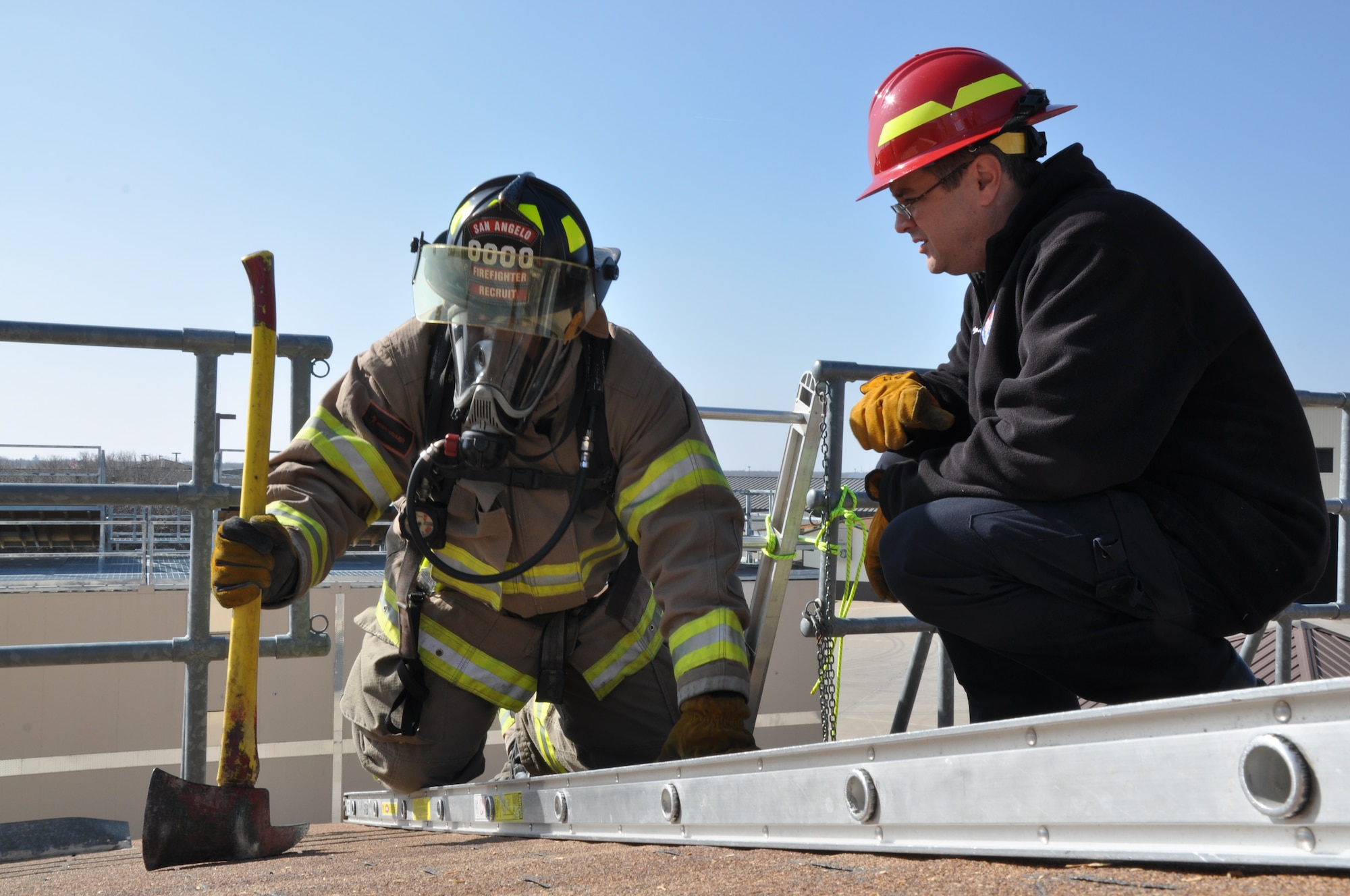 GOODFELLOW AIR FORCE BASE, Texas – Lt. Stacy Wright, San Angelo Fire Department Station Seven, instructs Edward Cooper, SAFD recruit, on how to check for weak spots in the roof during tactical ventilation training at the Louis F. Garland DOD Fire Academy here Feb. 19. Wright also instructed Cooper and other recruits how to use the ladder for proper footing and as a place to secure their tools. (U.S. Air Force photo/ Senior Airman Joshua Edwards)