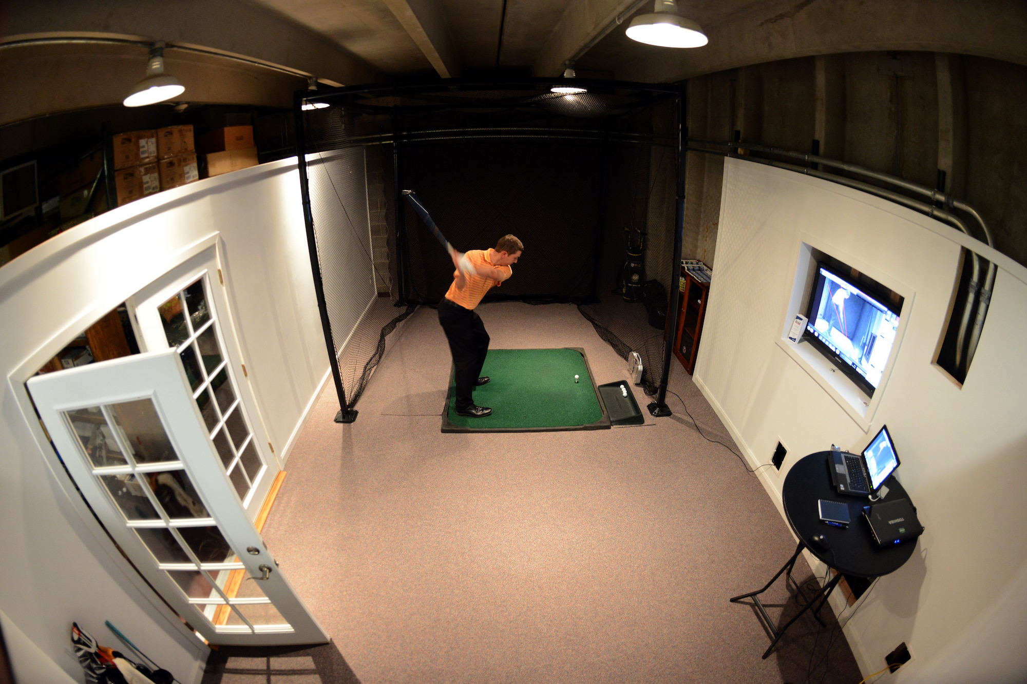 Chris Hyten, an instructor at the Silver Spruce Golf Academy, tests out the equipment prior to the open house March 1. During the open house, the instructors will give free 15 minute lessons where seasoned golfers and newcomers to the sport will have the opportunity to sample the video lessons in the studio. (U.S. Air Force photo/Tech. Sgt. Jared Marquis)