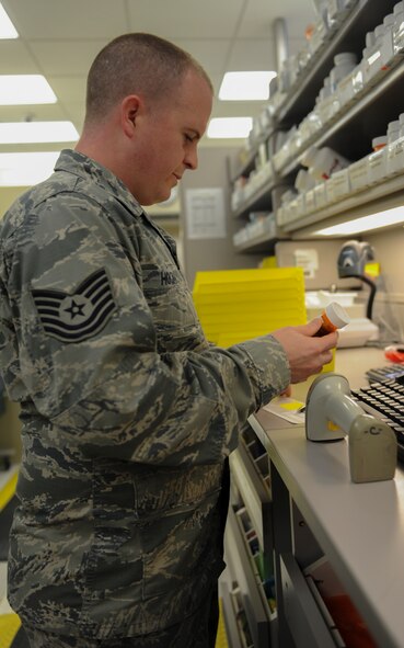 U.S. Air Force Tech Sgt. Allan Hogan, 23d Medical Support Squadron NCO in charge of pharmacy services, labels a bottle of medicine on Moody Air Force Base, Ga., Feb. 25, 2014. After labeling the bottle, Hogan double checks the information on the label to insure it is correct. (U.S. Air Force photo by Airman 1st Class Alexis Millican/Released)
