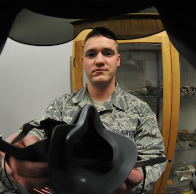 Airman 1st Class Anthony Patterson, 509th Operations Support Squadron aircrew flight equipment specialist, demonstrates how the MBU-20/P soft shell mask fits onto a pilots face. AFE technicians inspect all the safety equipment on a daily basis. (U.S. Air Force photo by Airman 1st Class Joel Pfiester/Released)