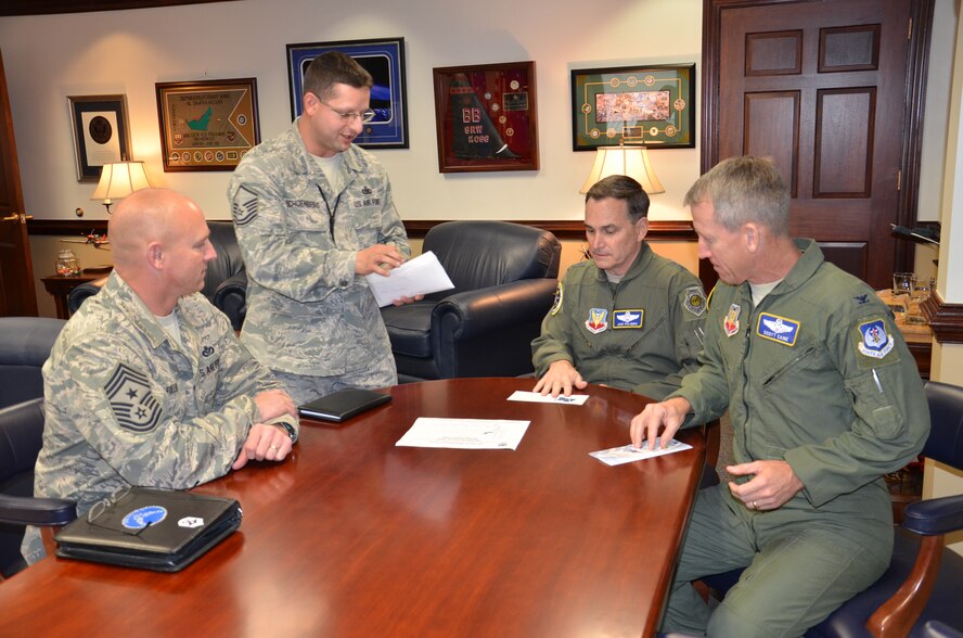 U.S. Air Force Master Sgt. Joseph Schoenberg presents Air Force Assistance Fund informational packets and pledge forms to Ninth Air Force leaders, Chief Master Sgt. Scott Fuller, command chief, Maj. Gen. Jake Polumbo, commander, and Col. Scott Caine, vice commander, Feb. 14, 2014 at Shaw Air Force Base, S.C. The Air Force Assistance Fund was established to provide for an annual effort to raise funds for the charitable affiliates that provide support to the Air Force family (active duty, retirees, reservists, guard and their dependents, including surviving spouses) in need. These organizations are the Air Force Villages, Inc., the Air Force Aid Society, Inc., the General and Mrs. Curtis E. LeMay Foundation, and the Air Force Enlisted Village, Inc. These organizations help Air Force people with aid in an emergency, with educational needs, or to have a secure retirement home for widows or widowers of Air Force members in need of financial assistance. This year's AFAF campaign will be conducted at active duty Air Force installations between February and May. (U.S. Air Force photo by Master Sgt. Kristina Barrett/Released)