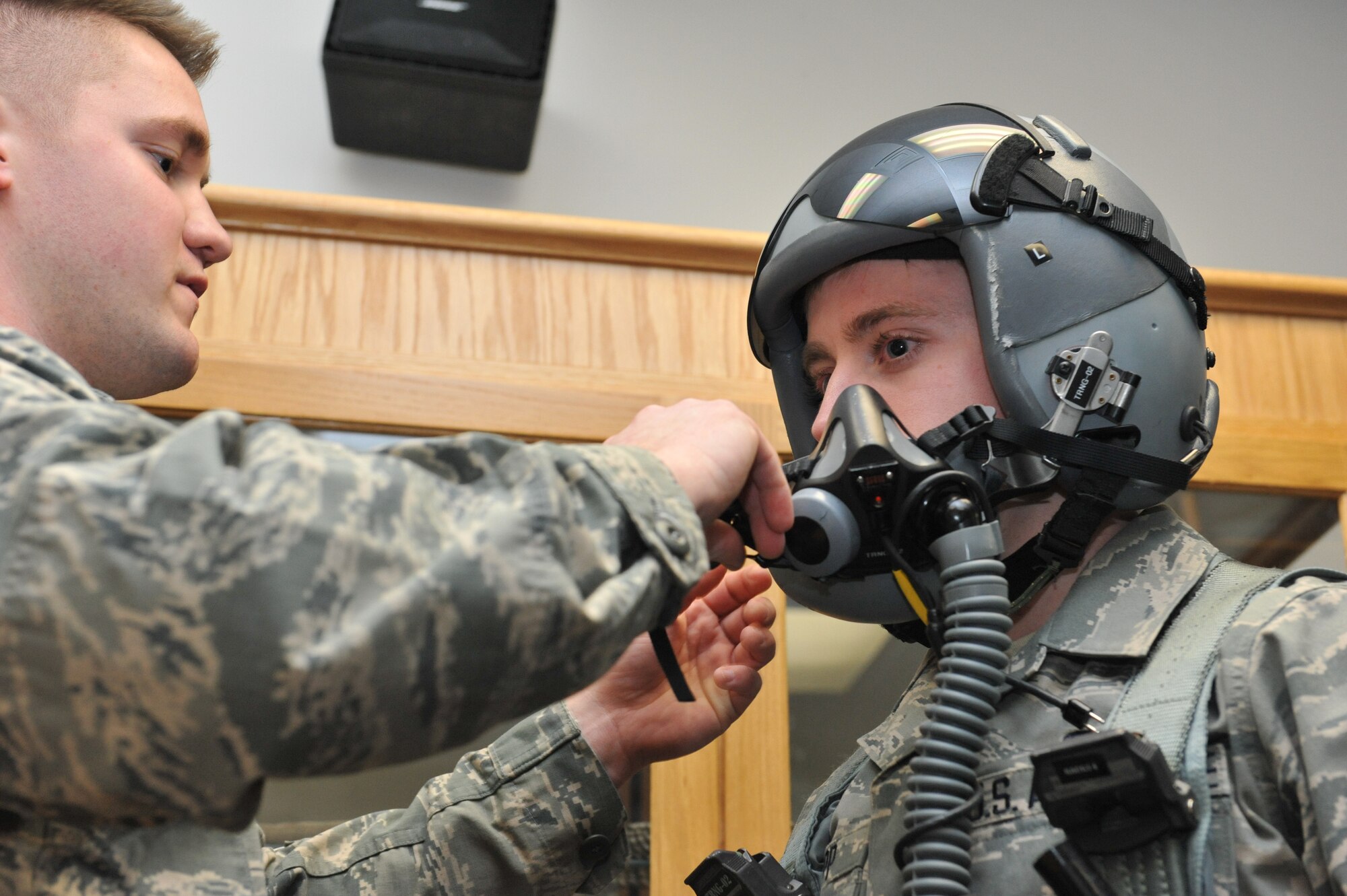 Airman 1st Class Anthony Patterson and Airman 1st Class Adam Clapp, 509th Operations Support Squadron aircrew flight equipment technicians, demonstrate how to fit a pilots helmet and MBU-20/P soft shell mask. The mask provides oxygen to the pilot while flying at high altitudes. (U.S. Air Force photo by Airman 1st Class Joel Pfiester/Released)