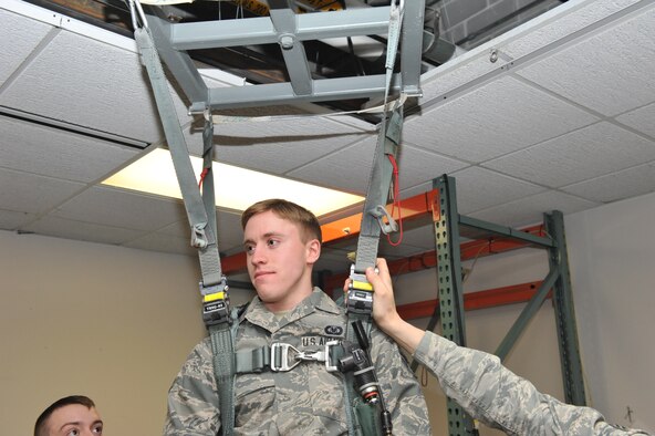 Airman First Class Adam Clapp, 509th Operations Support Squadron aircrew flight equipment technician, demonstrates hanging harness training at Whiteman Air Force Base Mo., Feb. 12, 2014. The training is used to simulate a situation when a pilot or aircrew member’s parachute gets caught on telephone wires or trees. (U.S. Air Force photo by Airman 1st Class Joel Pfiester/Released)